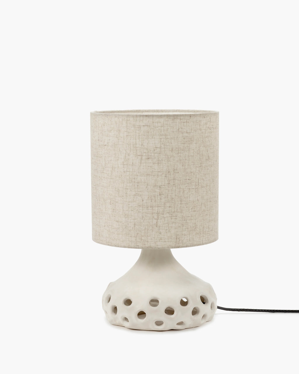Lampe à poser en grès organique avec abat jour en tissu beige clair et pied de lampe avec des trous
