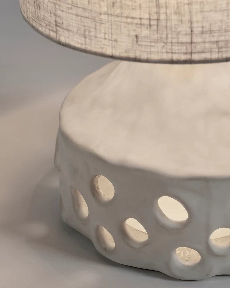 Lampe en grès blanche avec pied de lampe à trous et abat jour en tissu beige clair