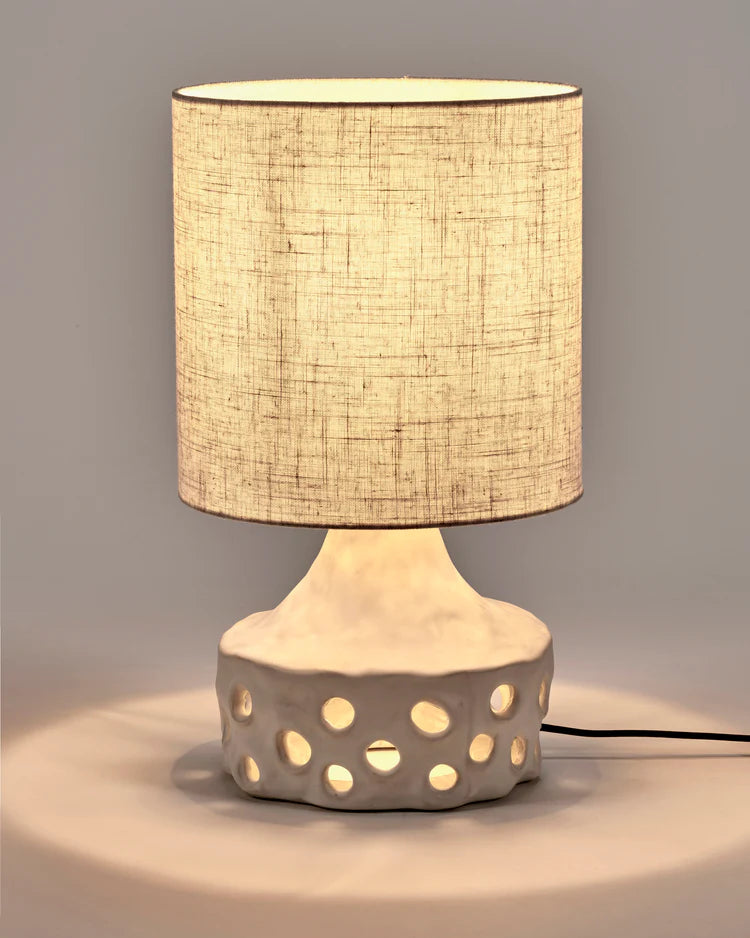 Lampe en grès blanche avec pied de lampe à trous et abat jour en tissu beige clair