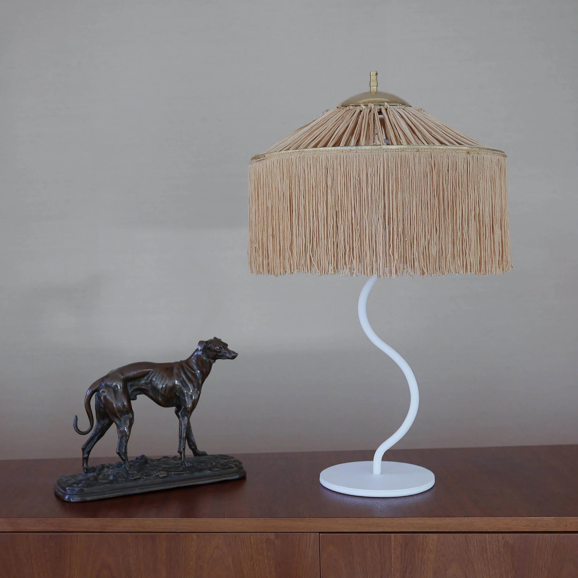 lampe à poser abat jour raphia et franges dorés structure en fer blanc ondulée